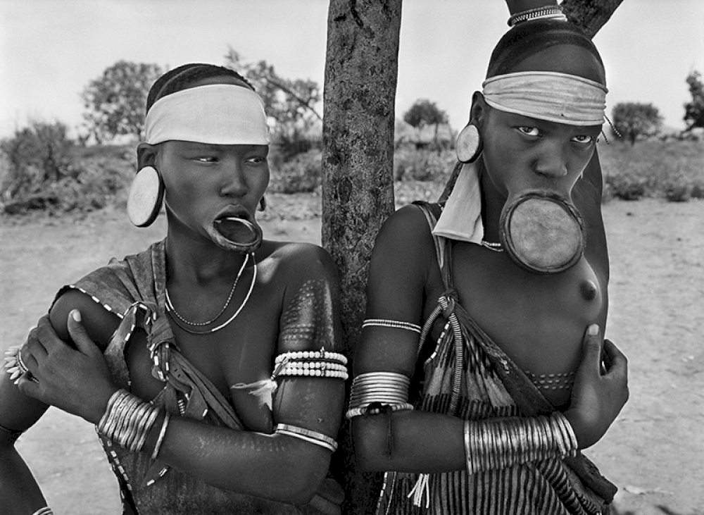 The Mursi and the Surma women are the last women in the world to wear lip plates.  Mursi village of Dargui in Mago National Park, in the Jinka Region. Ethiopia. 2007. © Sebastião Salgado / Amazonas images