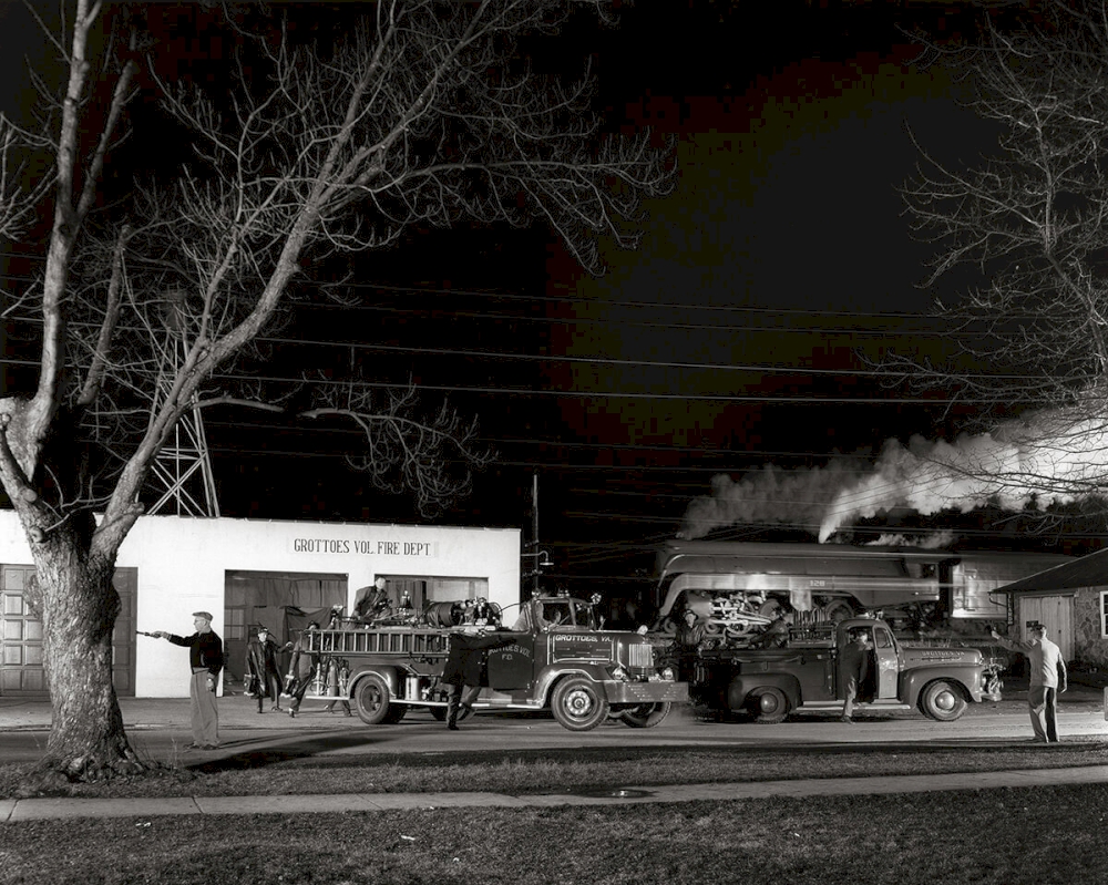 THE GROTTOES VOLUNTEER FIRE DEPARTMENT ANSWERS THE CALL AS TRAIN NO. 2 PASSES IN THE BACKGROUND Grottoes, Virginia, 1957 © O. Winston Link / O. Winston Link Museum, Roanoke, Virginia